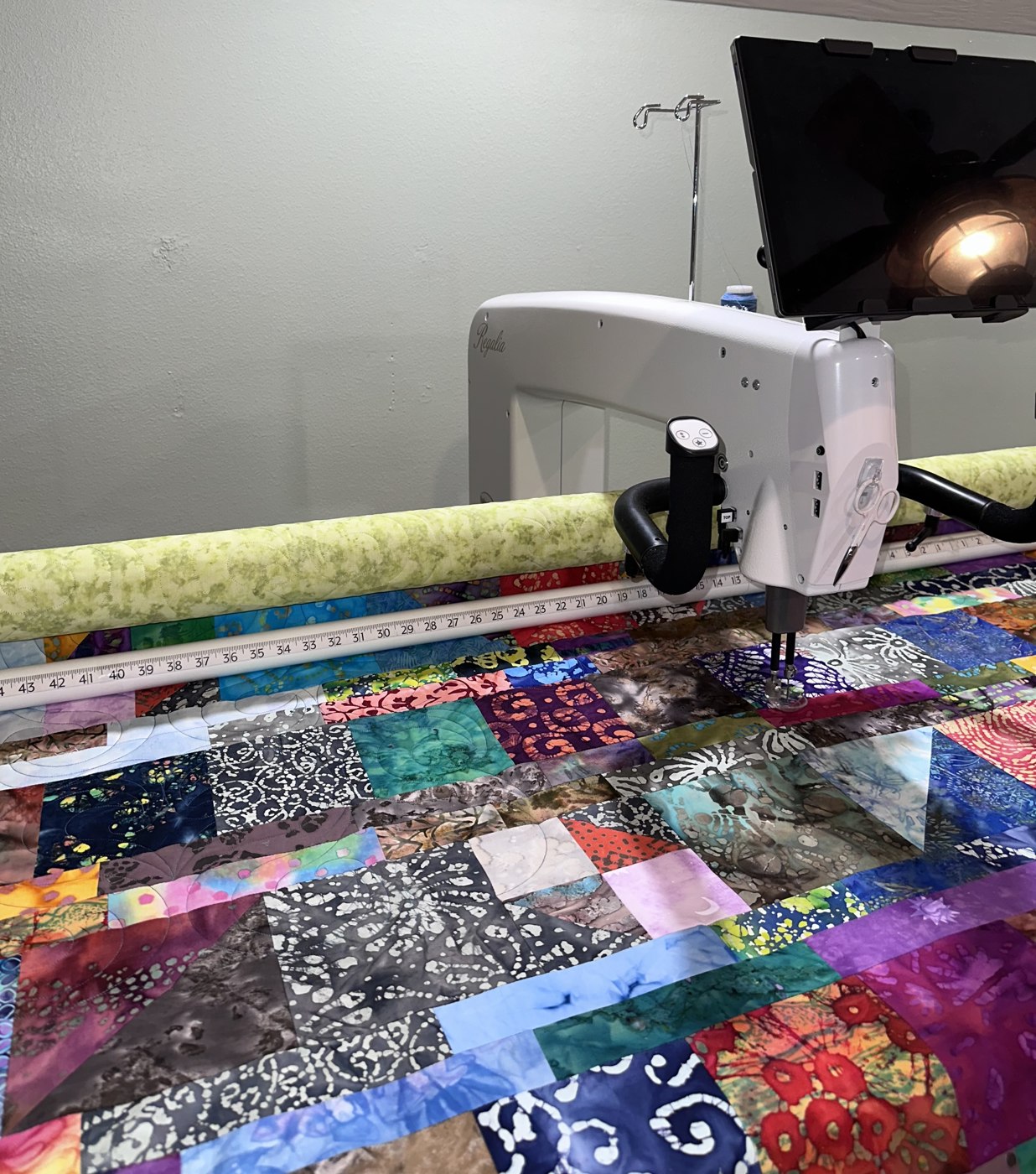 The studio’s longarm quilting machine at work on colorful patchwork